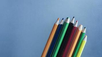 lápices de colores sobre un fondo azul foto