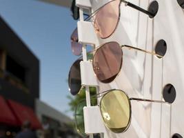 lentes de sol en el mostrador. tres pares de gafas de sol de diferentes colores foto