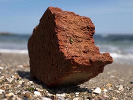 red brick on the seashore against the background of the sea and blue sky photo