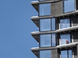 Constructor en casco en el piso de un edificio de gran altura en construcción contra el cielo azul foto