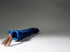 Blue cable twisted on grey background.electrical insulated wire photo