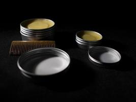Beard and mustache wax and wooden comb on black background photo