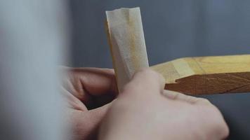 Artesano de madera muele los dientes en un peine de madera con papel de lija