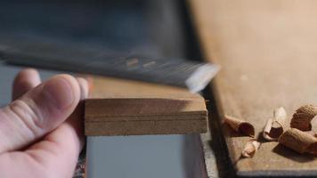 chisel work. craftsman carpenter removes excrd with aess thickness from a wooden boa flat chisel. video