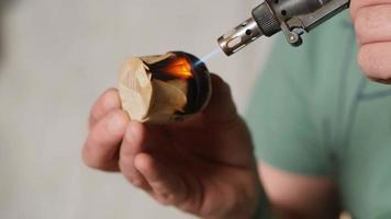 um marceneiro queima um pedaço de madeira com um queimador de gás video