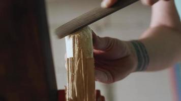 a joiner processes a piece of wood with a file. video