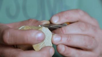 a woodcarver carves a helmet of a robot or a knight with a knife video