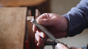 A carpenter removes chamfer from a piece of wood with a chisel. video