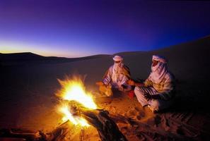 Tikobaouine Algeria 2010- Unknown people in front of the fire at sunset in the Tassili n'Ajjer desert photo