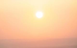 Symmetric orange sunset with silhouetted hills photo