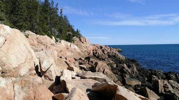 Beautiful day with blue sky and Atlantic ocean with big rocks on Maine coastline