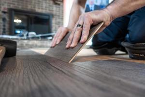 man installing engineered laminate wood floring indoor photo