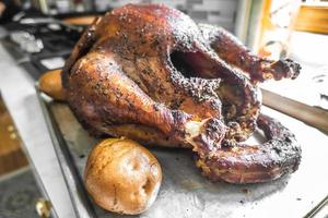 smoked whole turkey and potatoes on a tray ready for lunch and dinner photo