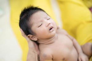 Mother is holding a newborn baby in her arms. Selective focus photo