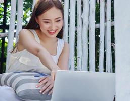 Asian women work at home with laptops Working online at home photo