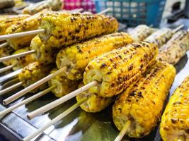 Delicious grilled corn, Grilled corns on the grille over fire at night market photo