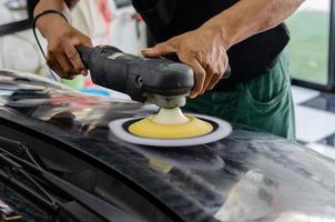 Car detailing - Man working on polishing and caring the exterior with wax. Auto polishing with machine photo