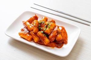 Korean rice cake stick with sausage in spicy sauce - Tteokbokki photo