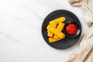 Crispy fried fish fingers with breadcrumbs served on plate with ketchup