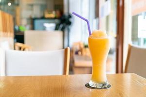 Mezcla de jugo de naranja batido de vidrio en café restaurante foto
