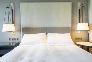 White pillows decoration on bed in bedroom interior photo