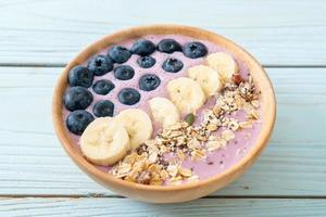 tazón de yogur o batido con arándanos, plátano y granola - estilo de comida saludable foto