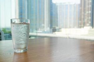 Water glass with ice on table photo