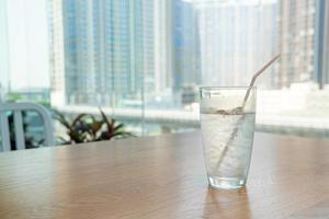 Water glass with ice on table photo