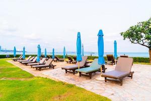 Chair pool or bed pool and umbrella around swimming pool with sea beach background at Pattaya in Thailand photo