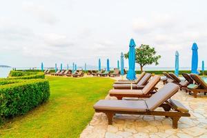 Chair pool or bed pool and umbrella around swimming pool with sea beach background at Pattaya in Thailand photo