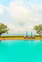 Chair pool and umbrella around swimming pool with ocean sea background photo