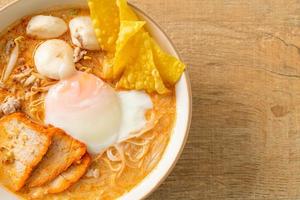 fideos de arroz con albóndigas, cerdo asado y huevo en sopa picante