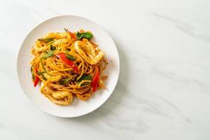 Stir-fried spaghetti with salted egg and squid - fusion food style photo