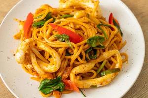 Stir-fried spaghetti with salted egg and squid - fusion food style photo