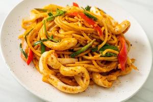 Stir-fried spaghetti with salted egg and squid - fusion food style photo