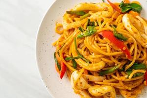 Stir-fried spaghetti with salted egg and squid - fusion food style photo