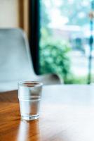 Glass of water on wood table photo