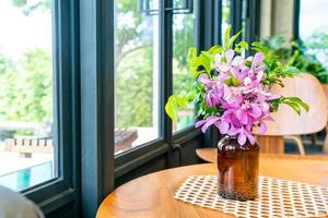 Orchid flowers in vase decoration on table in coffee shop cafe restaurant photo