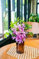 Orchid flowers in vase decoration on table in coffee shop cafe restaurant photo