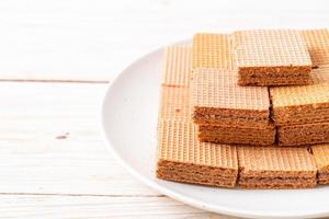 Chocolate wafers with chocolate cream on wood background