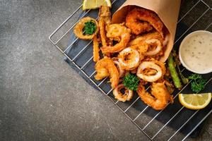 mariscos fritos de camarones y calamares con vegetales mixtos - estilo de comida poco saludable foto