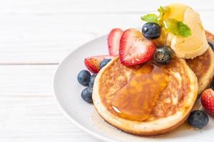 Souffle pancake with blueberries, strawberries, honey, and vanilla ice-cream photo