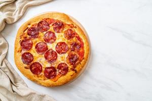 Pizza de pepperoni en bandeja de madera - estilo de comida italiana foto