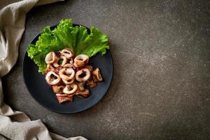 Grilled squid on black plate photo