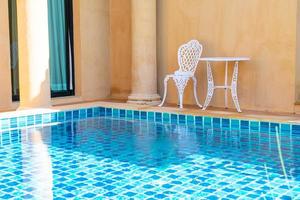Empty white chair and table on side the swimming pool photo