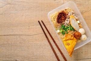 Fideos con bola de pescado y carne de cerdo picada en caja de entrega - estilo de comida asiática foto