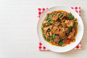 Panceta de cerdo crujiente salteada y albahaca - estilo de comida callejera local asiática foto