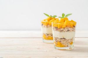 Yogur de mango fresco con granola en vidrio - estilo de comida saludable
