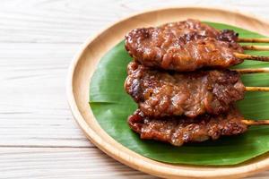 Grilled skewered milk pork with white sticky rice - local Thai street food style photo