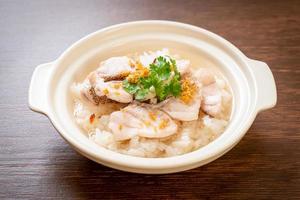 Porridge or boiled rice soup with fish bowl photo